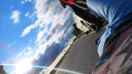 Motorcycle driver on the road with blue sky and white clouds.の写真素材