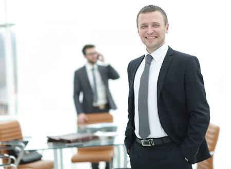 Handsome mature business man standing with his collegues in backの写真素材