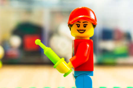 Poznan, Poland - May 13, 2020: Female Lego doctor holding a syringe.のeditorial素材