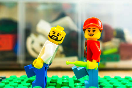 Poznan, Poland - May 13, 2020: Lego female woman trying to give escaping man an injection.のeditorial素材