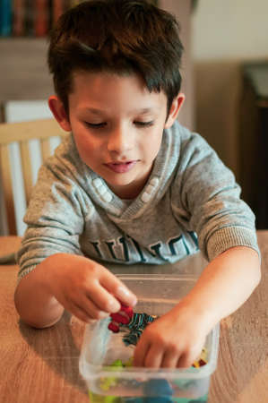 Poznan, Poland - May 15, 2020: Six years old young Caucasian Polish boy playing with plastic toy...