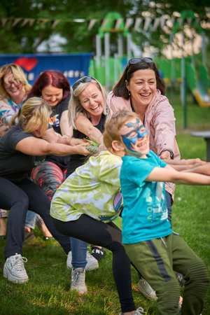 Poznan, Poland - July 20, 2023: Group of people pulling a rope during a kindergarten festivalのeditorial素材