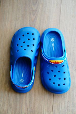 Poznan, Poland - July 2023: Two blue home shoes on a wooden floorのeditorial素材