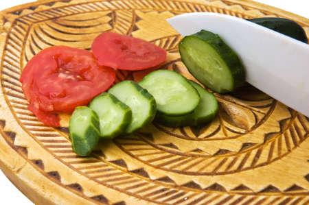 tomatoes and cucumber on a cutting board and knifeの写真素材