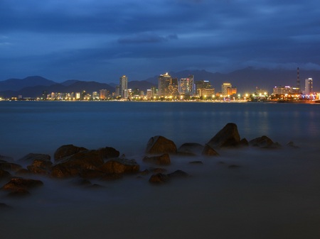 Nha Trang city skyline slow exposure over the bay just after sunset with the city lights ablaze.の写真素材