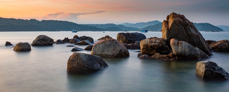 A rocky coastline at sunset looking out over the south China sea in Vung Lam Bay Vietnam.の写真素材