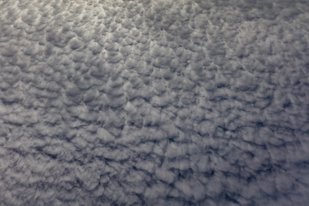Fluffy white cloud formation summer sky abstract background pattern.の写真素材