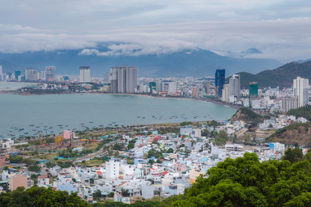 Holiday resort Nha Trang Vietnam on a cloudy day from a view point north of the city. With the mountains in the background and the turquoise south china sea to the left.のeditorial素材