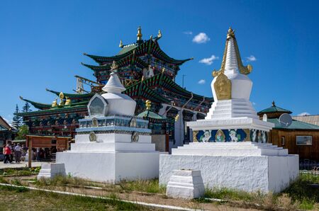 Stupas - buddhist symbols of enlightenment and mind in fornt of the beautiful colorful temple at the...