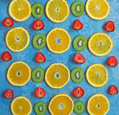 An assortment of fresh fruits, berries and nuts on a wooden Board. Healthy eating. Blue background.の写真素材