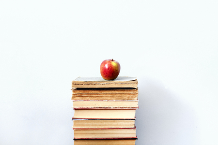 Apple on a stack of books on white backgroundの写真素材