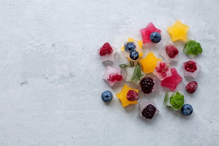 Ice cubes with berries and herbs in the form of a starの写真素材