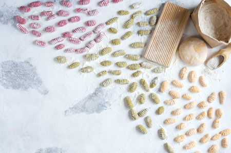 Homemade raw gnocchi with spinach, carrots and beets on the table with the Boardの写真素材