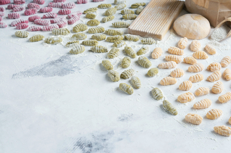 Homemade raw gnocchi with spinach, carrots and beets on the table with the Boardの写真素材