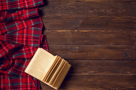 Red blanket with a book on wooden backgroundの写真素材