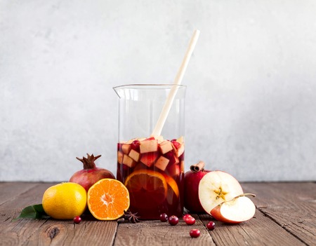 Sangria with apples, cranberries and orange in a bottleの写真素材