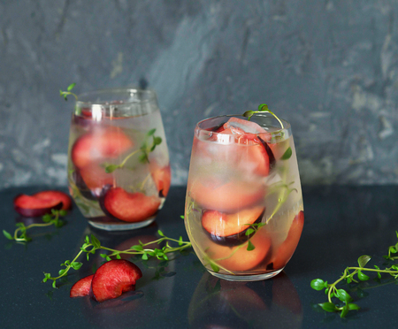 A cocktail of Prosecco with plums and thymeの写真素材
