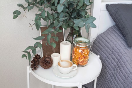 Eucalyptus in the interior, morning coffee on the table in the bedroom by the bedの写真素材