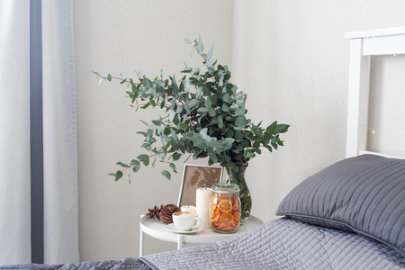 Eucalyptus in the interior, morning coffee on the table in the bedroom by the bedの写真素材