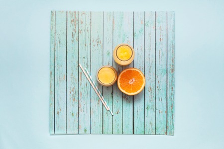 Freshly squeezed orange juice on a turquoise background. Copy spaceの写真素材