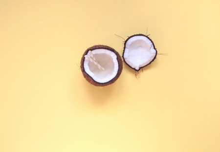Coconut water in coconut on yellow background. Copy spaceの写真素材
