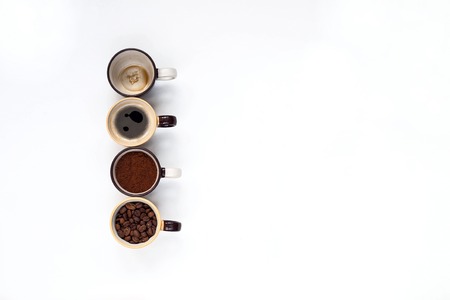Cups with coffee beans, a rock and drunk a Cup on a white kitchen table. View from above with copyspace for your textの写真素材