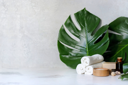 Spa and massage treatments on white, marble background monstera leaves. Flat lay. Top viewの写真素材