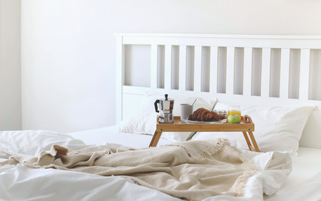 Morning Breakfast in bed. Coffee croissants, fresh orange juice. Copy space.