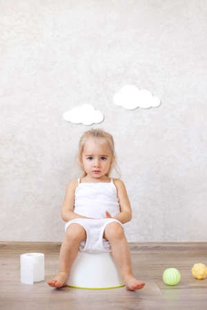 A little baby girl is sitting on a potty. Potty training. children's hygiene.の写真素材