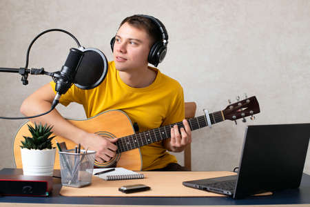 The guy in live online live records podcasts, plays guitar and harmonica. He communicates with people, smiles, and runs his own music blog.の写真素材