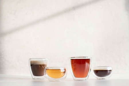 Soft drinks in double-walled glasses. Taken in harsh sunlight on a gray background.の写真素材