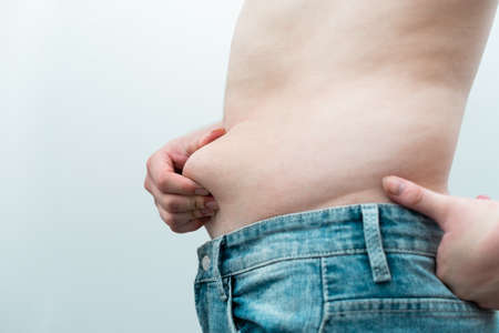 image of man's obese belly, isolated on white backgroundの写真素材