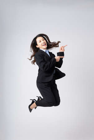 Asian female waitress portrait, isolated on blue backgroundの写真素材