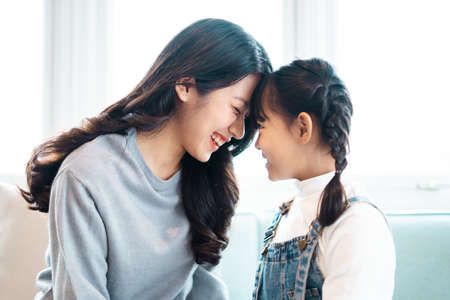 image of mother and daughter cuddling on the sofa