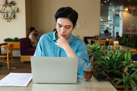 Image of Young asian businessman with glass building backgroundの写真素材