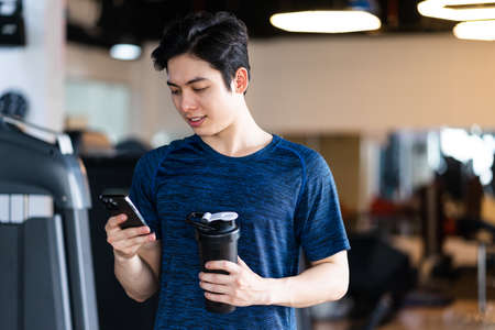 Image of Young asian businessman with glass building background