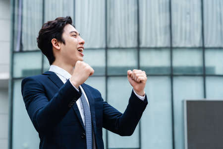 Image of Young asian businessman with glass building backgroundの写真素材