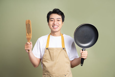 Asian young man posing on a yellow backgroundの写真素材