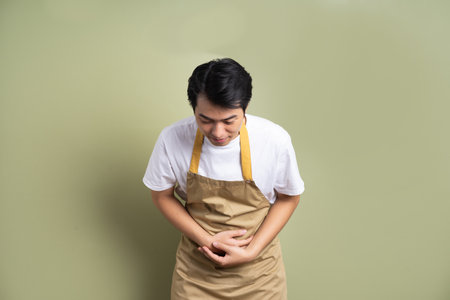 Asian young man posing on a yellow backgroundの写真素材