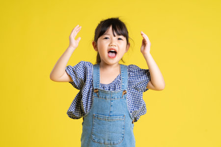 full body image of beautiful asian baby girl on yellow background