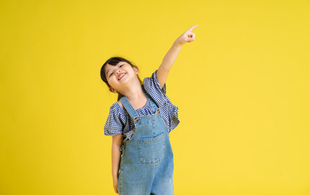 portrait of a beautiful asian girl, isolated on yellow background
