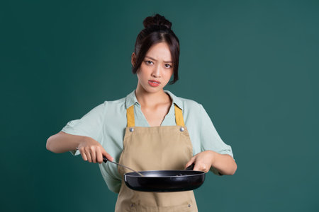 Asian woman wearing apron and holding a panの写真素材