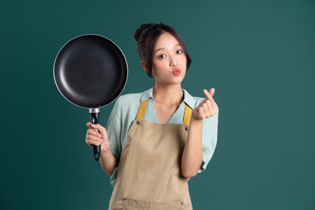 Asian woman wearing apron and holding a panの写真素材