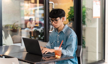 Portrait of Asian male student sitting at a coffee shop