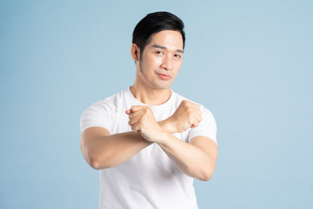 Asian male portrait posing on blue backgroundの写真素材