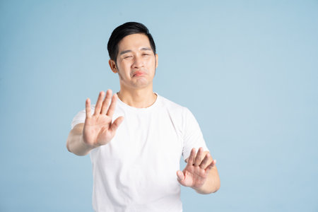 Asian male portrait posing on blue backgroundの写真素材