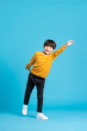 full body image of asian boy posing on blue backgroundの写真素材