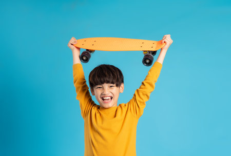 Asian boy portrait posing on blue backgroundの写真素材