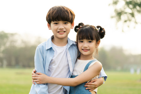 image of brother and sister having fun in the parkの写真素材