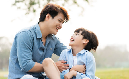 image of an asian father and son having fun in the parkの写真素材